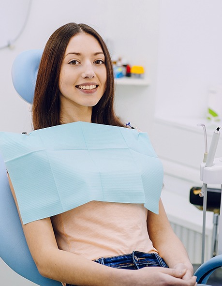 Smiling young woman in dental treatment chair