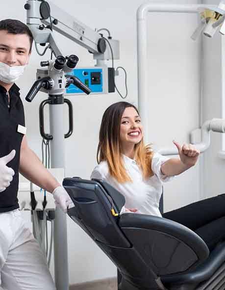 Woman and dentist giving thumbs up