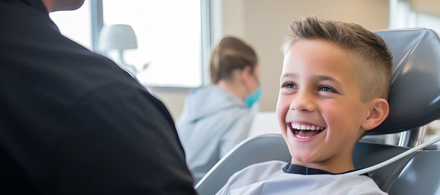 Young boy grinning in dental chair after childrens restorative dental treatment