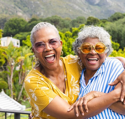 Two friends embracing and smiling while enjoying the outdoors