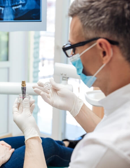 Dentist showing a dental implant to a patient