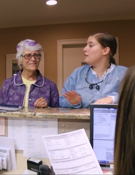 Senior woman talking to dental office receptionist