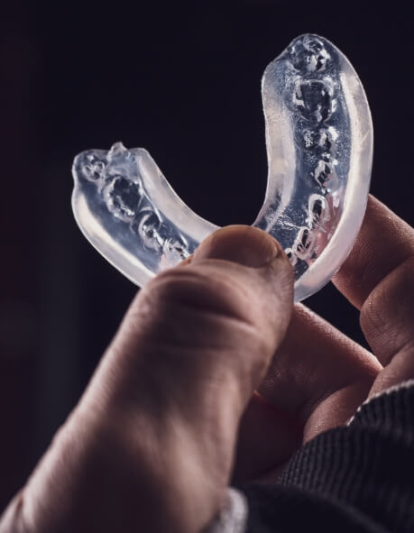 Hand holding a clear athletic mouthguard