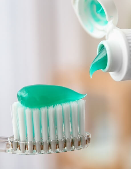 Toothpaste being squeezed onto a toothbrush