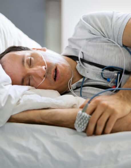 Sleeping man hooked up to electrodes for sleep testing