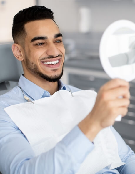 Dental patient looking at his smile in a mirror