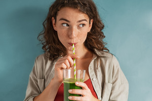 Drinking green liquid through a straw