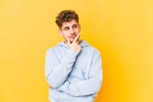 Curious young man wearing thoughtful expression